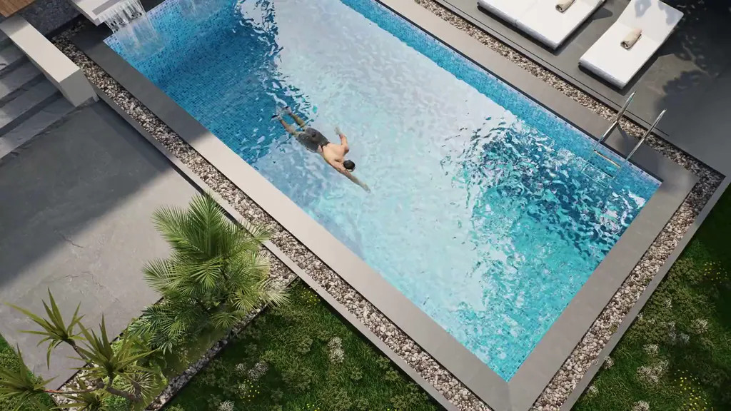 From above, a swimmer crosses a long blue pool between a stone deck and a garden