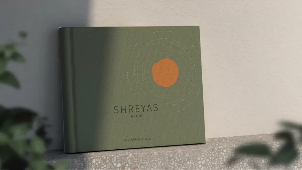 The Shreyas Arise brochure on a ledge, leaves stirring in the foreground