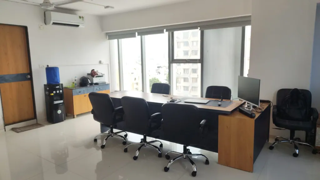 The Immersive Design studio in Ahmedabad: desks by a long window high above the city